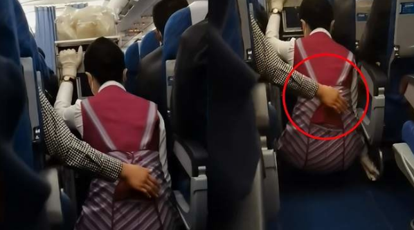 航班遇强气流空姐蹲下避险 女乘客伸手背后默默保护